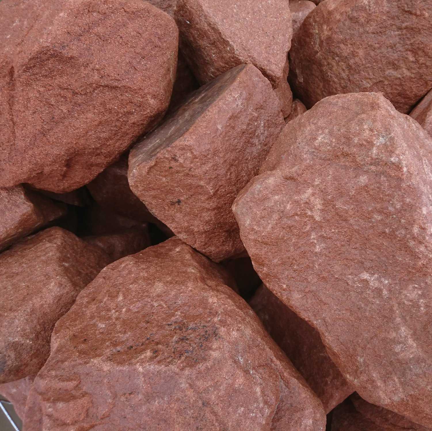 A close-up showcases a collection of 300-400mm Red Sandstone Rockery pieces, revealing their large, irregular shapes. Their rough, textured surfaces display varying shades of reddish-brown.