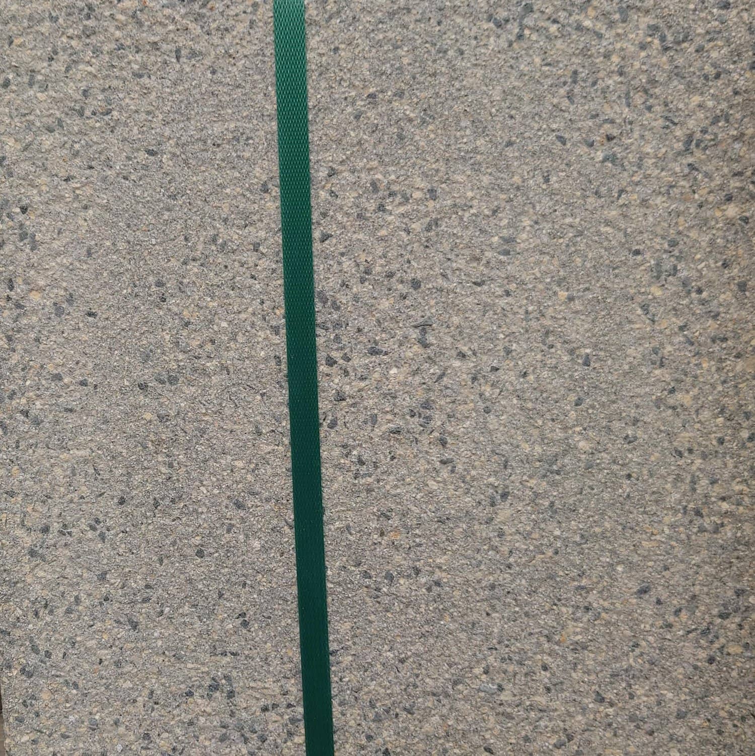 A Silver Grey Oakdale Centurion Textured concrete wall has a narrow green stripe on the left, enhancing its elegance.