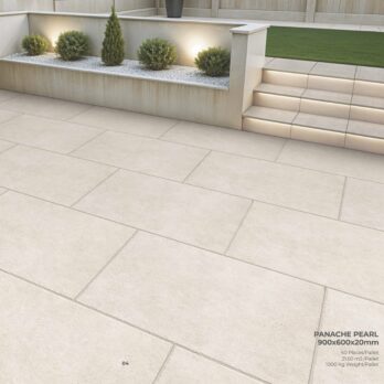 Modern outdoor patio featuring Premier Panache Pearl Porcelain tiles (900x600x20mm), a raised garden bed with white stones and green shrubs, steps with built-in lights, and a grass lawn above. Tile product details shown in the corner.