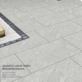 Premier Avantgarde Quartz Light Grey 21.6m² Porcelain tiles, designed to mimic Raj natural paving, are arranged in a staggered floor pattern beside white stones bordered by black tiles.
