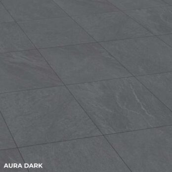 Aura Dark Porcelain 600x600x20mm Pack features dark gray stone-look tiles in a grid, with subtle veining and texture for an elegant finish. "AURA DARK" is displayed in white text at the lower left corner.