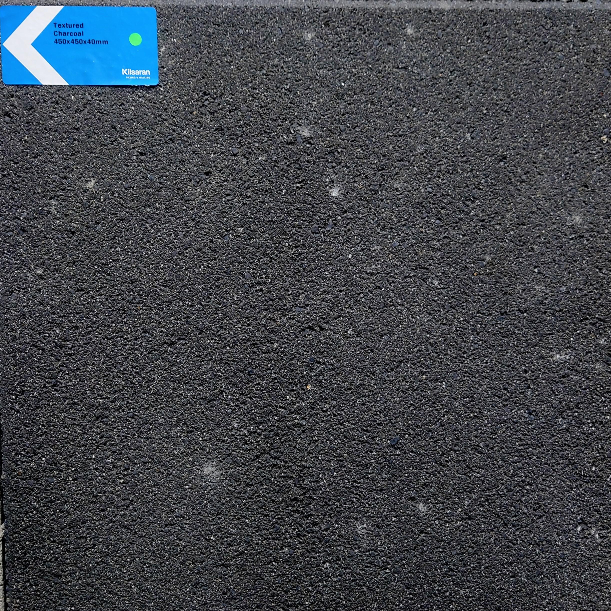 A close-up shows the Kilsaran Textured 450 x 450 x 40mm Charcoal Flag Stone, featuring a dark, subtly varied surface with a small blue 