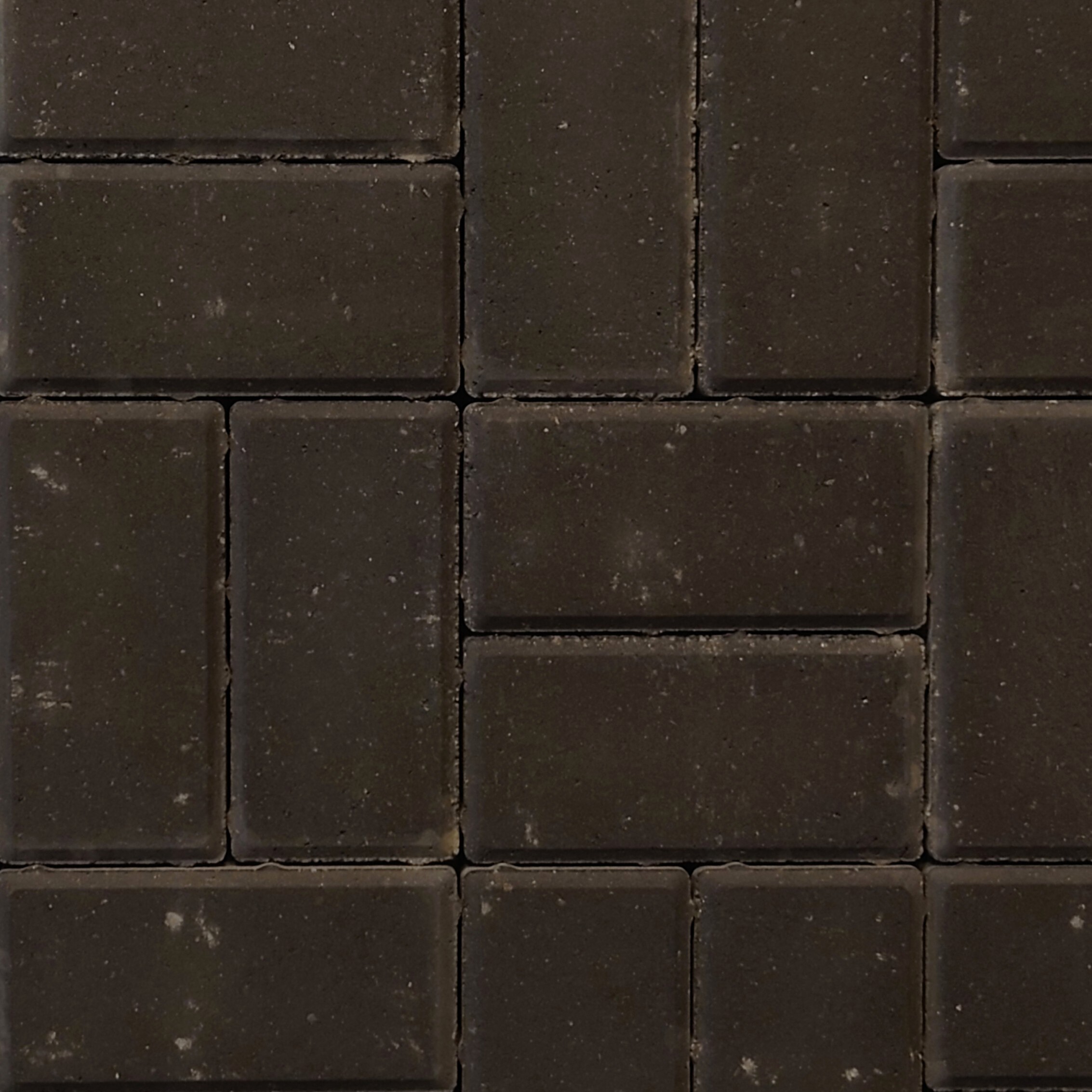 Close-up of a grid pattern made of dark brown Kilsaran Slane 50mm Driveway Charcoal block paving tiles, showing subtle color variations and small specks. The neatly aligned tiles have visible grout lines for a textured, rustic look.